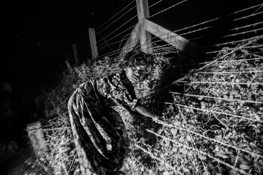 Girl crossing barbed wired border