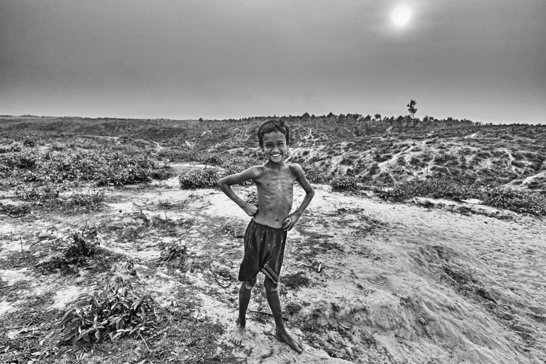 Boy standing shirtless in deserted land